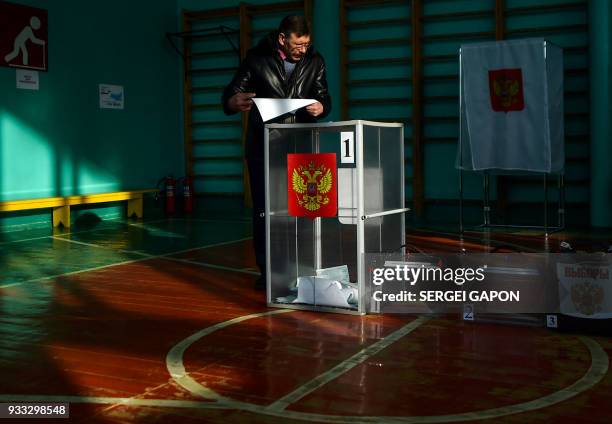 Man casts his ballot at a polling station during Russia's presidential election in the small town of Krasnyi, some 50 km north of Smolensk, on March...