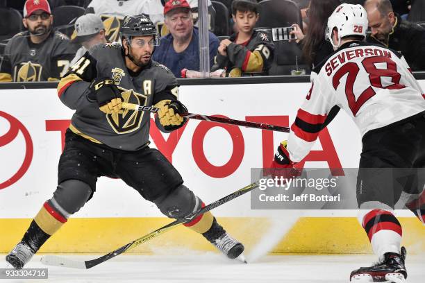 Damon Severson of the New Jersey Devils defends Pierre-Edouard Bellemare of the Vegas Golden Knights during the game at T-Mobile Arena on March 14,...