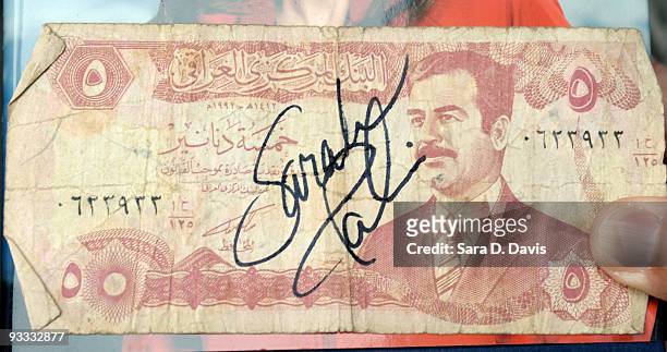 Former Alaska Gov. Sarah Palin's signature is seen on an Iraqi dinar note she signed for 82nd Airborne's Sgt. David Vogelslang during the signing of...