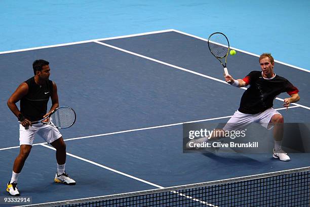 Lukas Dlouhy of Czech Republic returns the ball playing with Leander Paes of India during the men's doubles first round match against Lukasz Kubot of...