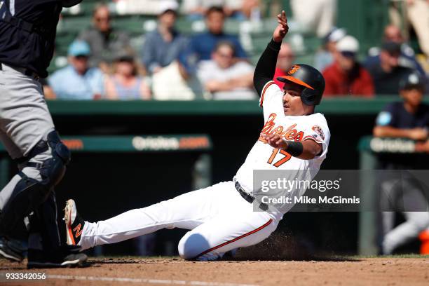 Ruben Tejada of the Baltimore Orioles slides into home plate during hr Spring Training game against the New York Yankees at Spectrum Field on March...