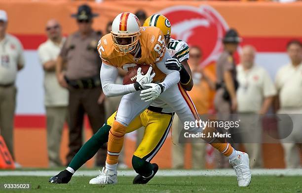 Receiver Maurice Stovall of the Tampa Bay Buccaneers is tackled by defensive back Charles Woodson of the Green Bay Packers during the game at Raymond...