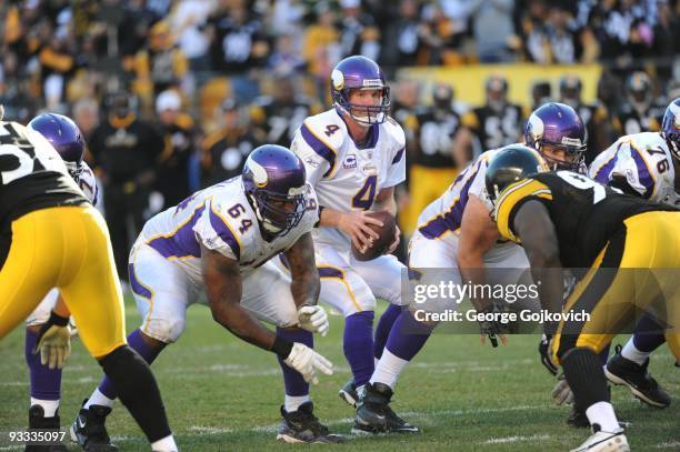 Quarterback Brett Favre of the Minnesota Vikings drops back to pass after taking the football from center John Sullivan as offensive lineman Anthony...