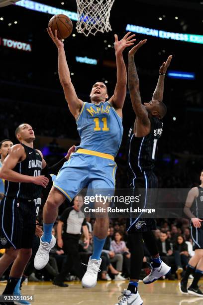 Brook Lopez of the Los Angeles Lakers attempts a lay up against Jonathon Simmons of the Orlando Magic on March 7, 2018 at STAPLES Center in Los...