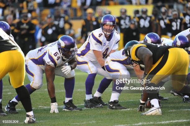 Quarterback Brett Favre of the Minnesota Vikings stands behind center John Sullivan as offensive lineman Anthony Herrera looks on during a game...