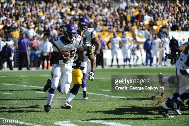 Running back Adrian Peterson of the Minnesota Vikings is pursued by linebacker James Harrison of the Pittsburgh Steelers during a game at Heinz Field...