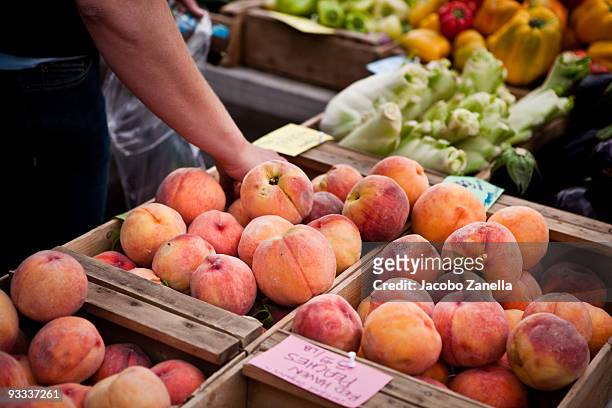 picking peaches at a farmers market - seattle market stock pictures, royalty-free photos & images