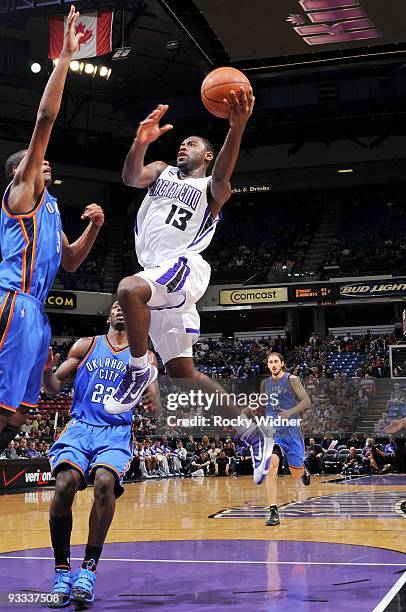 Tyreke Evans of the Sacramento Kings drives to the basket for a layup against Kevin Durant and Jeff Green of the Oklahoma City Thunder during the...