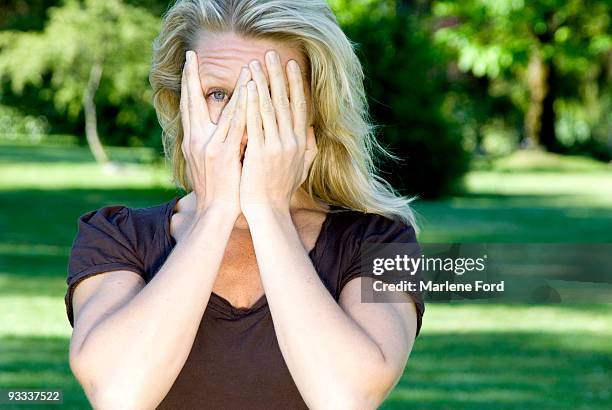 woman with hands partly covering face - hands covering eyes stock pictures, royalty-free photos & images
