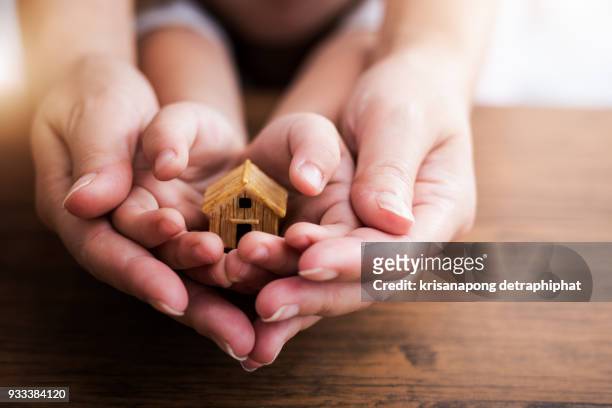 home concept,people, family and home concept - close up of woman and girl holding model house - family financial planning stock pictures, royalty-free photos & images