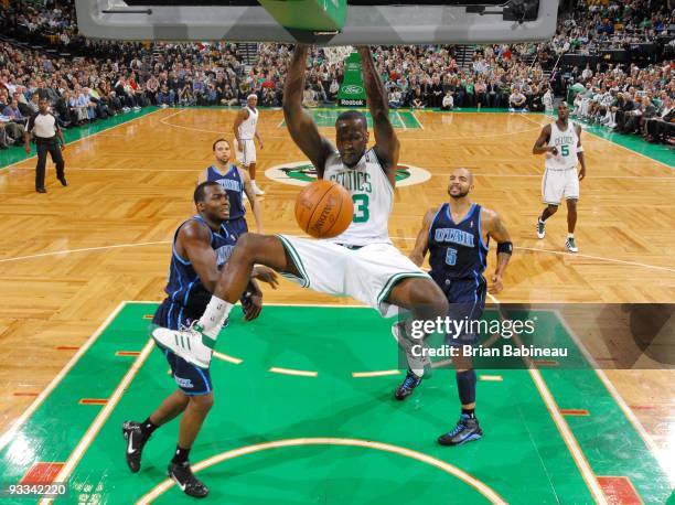 Kendrick Perkins of the Boston Celtics dunks against Paul Millsap and Carlos Boozer of the Utah Jazz during the game at The TD Garden on November 11,...