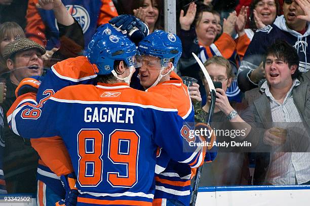 Sam Gagner and Dustin Penner of the Edmonton Oilers congratulate Ales Hemsky after Hemsky scored his 100th NHL goal, in the first period against the...