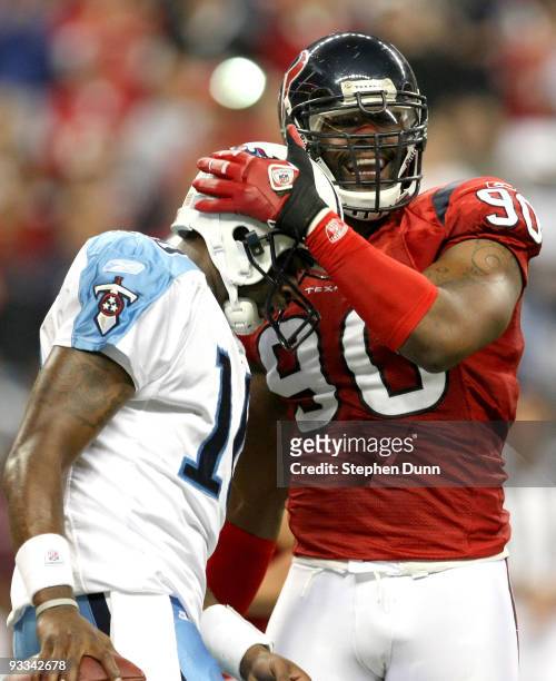 Defensive end Mario Williams of the Houston Texans laughs with quarterback Vince Young of the Tennessee Titans after a play was blown dead on...