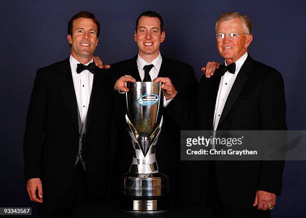 Kyle Busch , 2009 NASCAR Nationwide Series Champion, team owner Joe Gibbs and president of Joe Gibbs Racing, J.D. Gibbs pose with his trophy during...