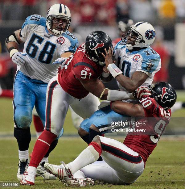Quarterback Vince Young of the Tennessee Titans is sacked by defensive end Mario Williams and defensive tackle Amobi Okoye in the fourth quarter at...