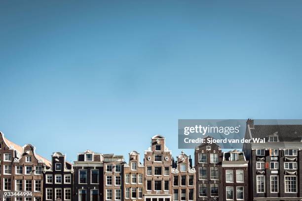 traditional old buildings facades at to the canals in amsterdam, the capitol of the netherlands. the ancient merchant's houses are located at the ring of canals in the city centre. - sjoerd van der wal or sjonature imagens e fotografias de stock