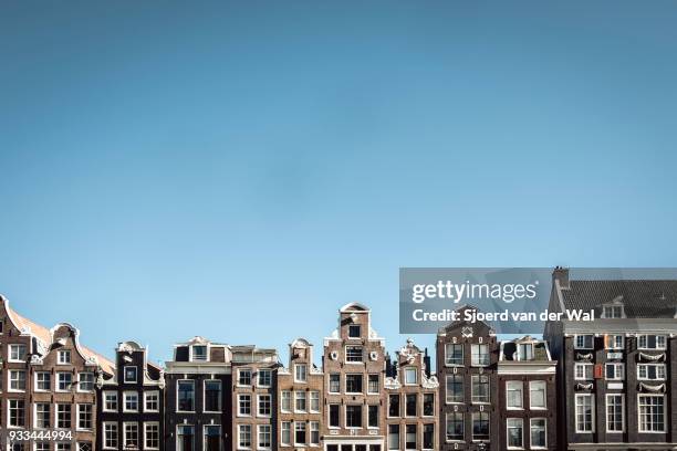 traditional old buildings facades at to the canals in amsterdam, the capitol of the netherlands. the ancient merchant's houses are located at the ring of canals in the city centre. - sjoerd van der wal or sjonature bildbanksfoton och bilder
