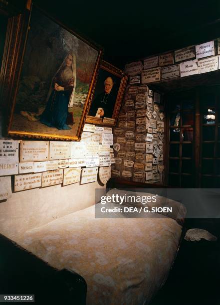 Bed of Bernadette Soubirous, with ex-voto, Moulin Lacade, Saint Bernadette Soubirous father's home, Lourdes, Languedoc-Roussillon-Midi-Pyrenees,...