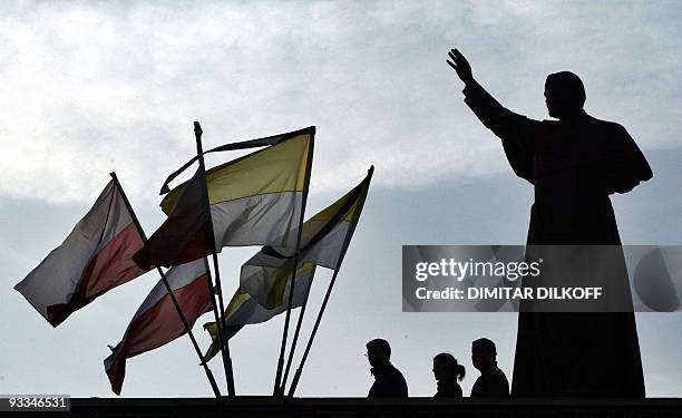 Pilgrims pray next to the statue of the Pope John Paul II outside of the basilica of Black Madonna in Jasna Gora Monastery in Czestochowa, 03 April...