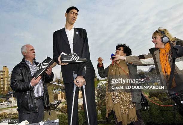 The tallest man in the world Sultan Kosen , of Turkey, receieves a pair of trainers on November 9, 2009 in the Hague from Georg Wessels , a...
