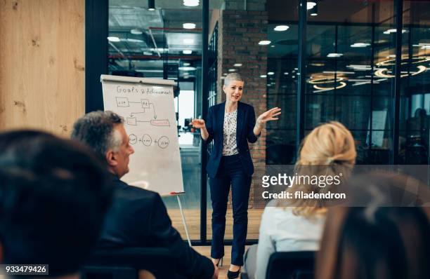 businesswoman speaking in front of audience - small group of people stock pictures, royalty-free photos & images