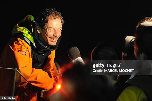 French yachtman Marc Guillemot speaks to the press aboard the monohull "Safran" on November 24, 2009 in Puerto Limon harbour, after winning with...