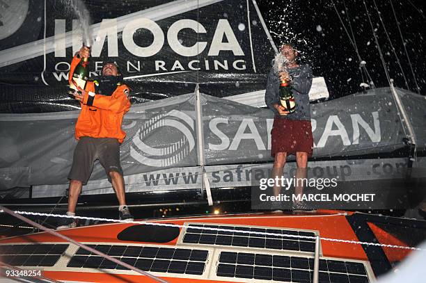 French skippers Marc Guillemot and Charles Caudrelier , spray champagne aboard their monohull "Safran" on November 24, 2009 in Puerto Limon harbour...