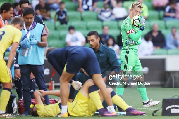 Anthony Golec of the Mariners reacts in pain after he crashes into Victory goalkeeper Lawrence Thomas in a contest and was later carried off on a...