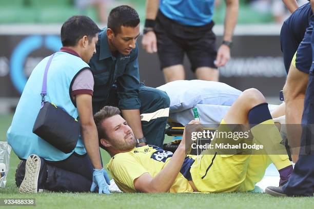 Anthony Golec of the Mariners reacts in pain after he crashes into Victory goalkeeper Lawrence Thomas in a contest and was later carried off on a...
