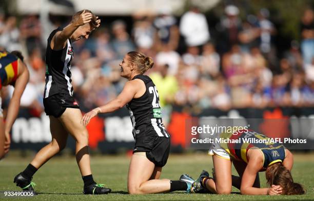 Emma Grant and Meg Hutchins of the Magpies celebrate as Jenna McCormick of the Crows slumps to the ground as the final siren sounds during the 2018...