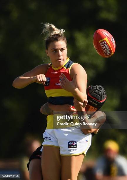 Jasmyn Hewett of the Crows handballs whilst being tackled during the round seven AFLW match between the Collingwood Magpies and the Adelaide Crows at...