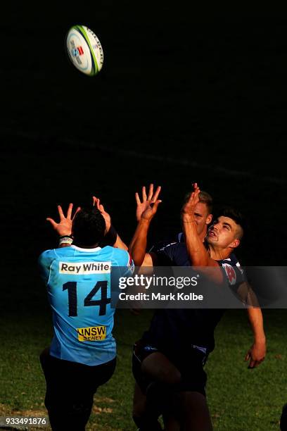 Israel Folau of the Waratahs and Jack Maddocks of the Rebels compete for the ball from a kick during the round five Super Rugby match between the...