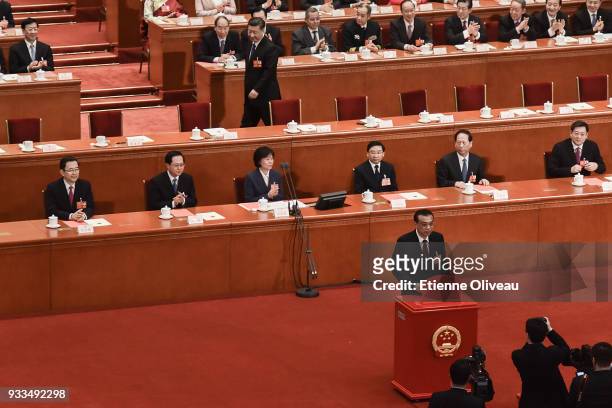 Chinese Premier Li Keqiang poses for a picture as Chinese President Xi Jinping reaches his seat after they casted their ballots during the sixth...