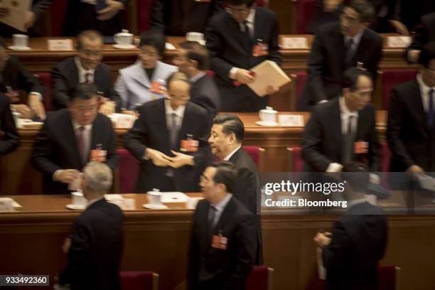 Xi Jinping, China's president, center, leaves following a session at the first session of the 13th National People's Congress at the Great Hall of...