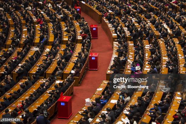 Delegates attend a session at the first session of the 13th National People's Congress at the Great Hall of the People in Beijing, China, on Sunday,...