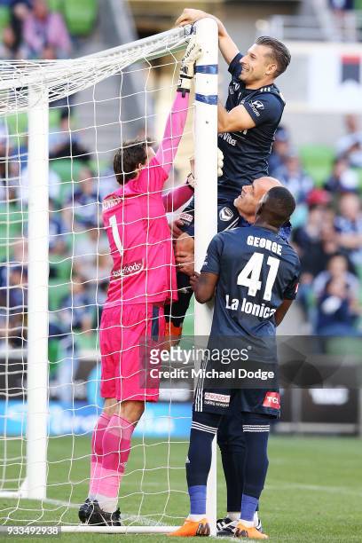 Kosta Barbarouses of the Victory is hoisted up to fix the broken net by Victory goalkeeper coach Dean Anastasiadis, Leroy George of the Victory and...