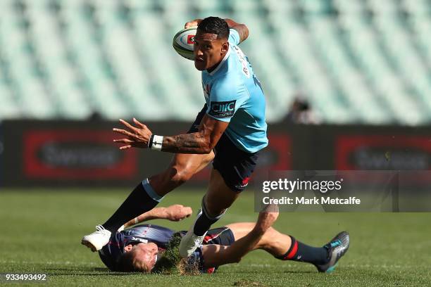 Israel Folau of the Waratahs evades the tackle of Reece Hodge of the Rebels during the round five Super Rugby match between the Waratahs and the...