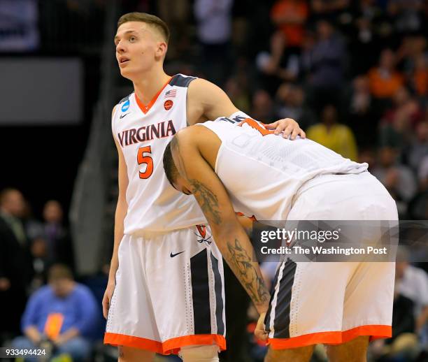 Charlotte NC Virginia guard Kyle Guy (5, left, gives comfort to the team's only senior, Virginia forward Isaiah Wilkins in the final minute of UMBC's...