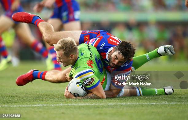 Blake Austin of the Raiders is tackled by Aidan Guerra of the Knights during the round two NRL match between the Canberra Raiders and the Newcastle...