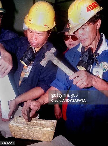 Workers at the Lepanto Mines marks a gold bar weighing 25 kg and worth about eight million pesos newly produced at the Mankayan mine site of the...