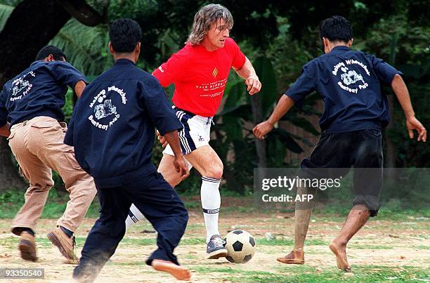 French soccer star David Ginola faces off a contingent of Cambodian mine victims during a friendly soccer game in Kompong Speu, 60 kms South from...