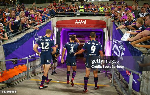 Billy Slater of the Melbourne Storm is chaired off by teammates Cameron Smith of the Melbourne Storm and Ryan Hoffman of the Melbourne Storm after...