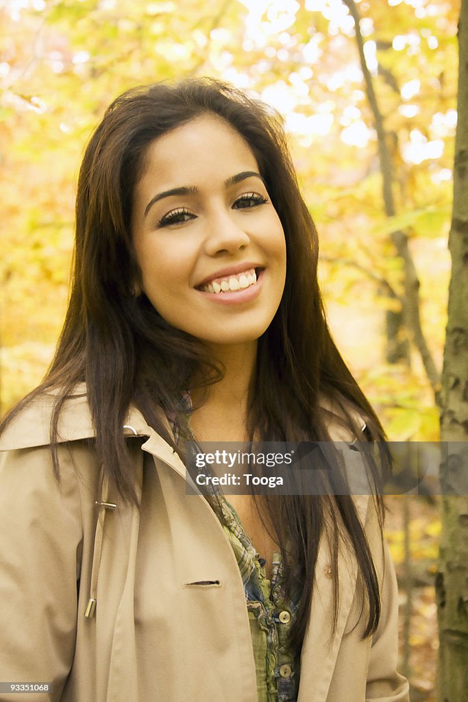 Portrait of young Hispanic female in fall foliage