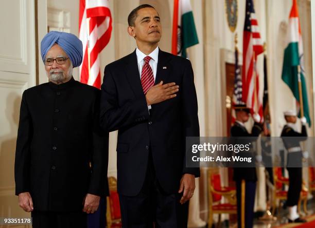 Indian Prime Minister Manmohan Singh , accompanied by U.S. President Barack Obama , listens to the American national anthem as they participate in a...