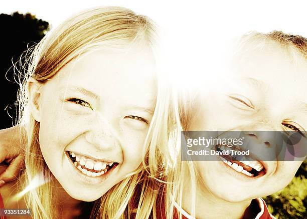 brother and sister laughing in the sunlight - david trood stock-fotos und bilder