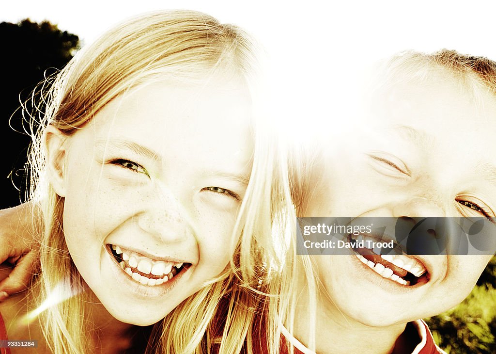 Brother and sister laughing in the sunlight