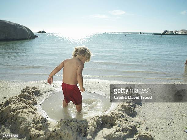 young boy playing by the sea. - david trood stock-fotos und bilder