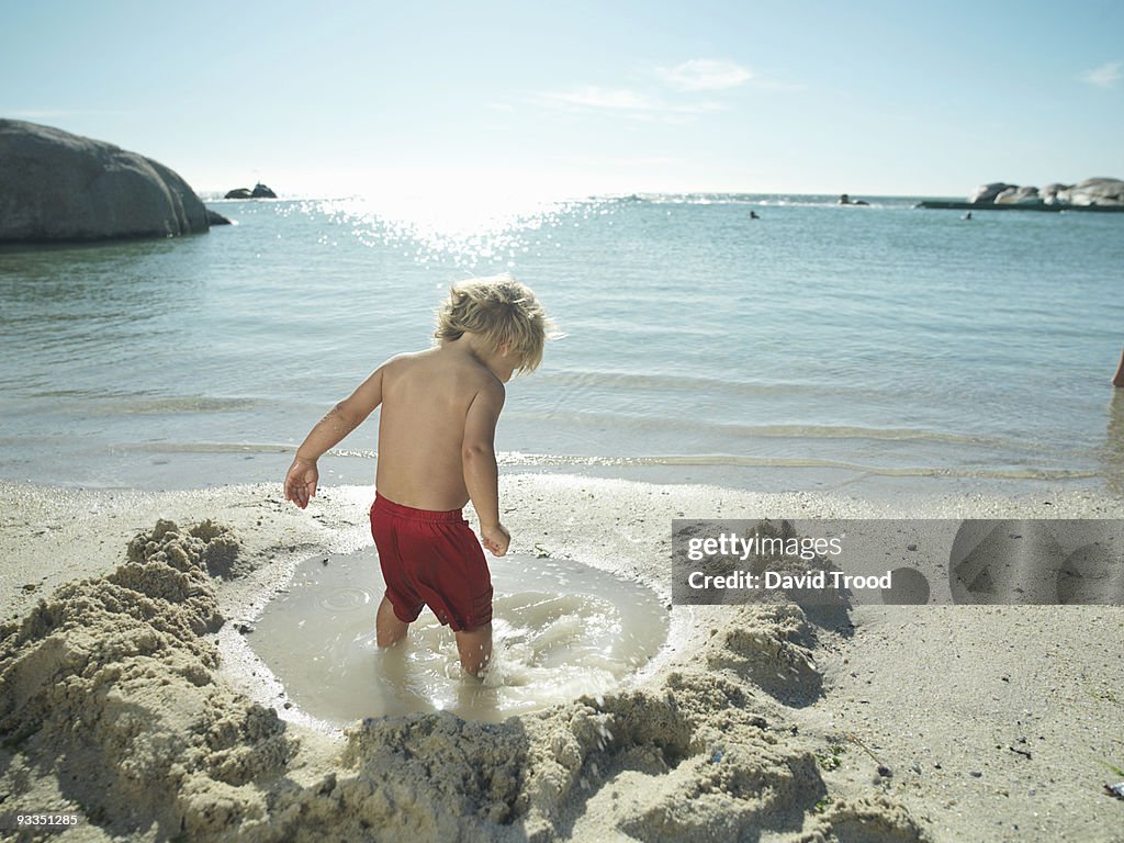 Young boy playing by the sea.