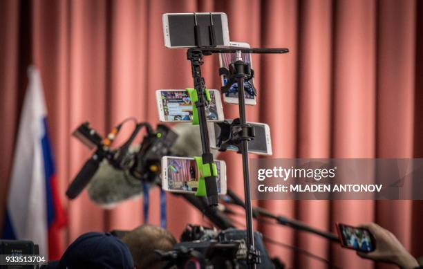 Mobile phones broadcast live stream on different social networks from a polling station during Russia's presidential election in Moscow on March 18,...