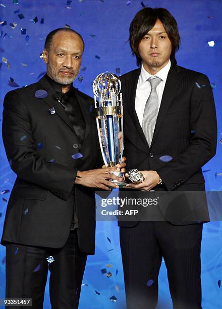 Japanese footballer Yasuhito Endo receives the Asian Football Confederation 2009 Men's Player of the Year award from AFC President Mohamed Bin Hammam...